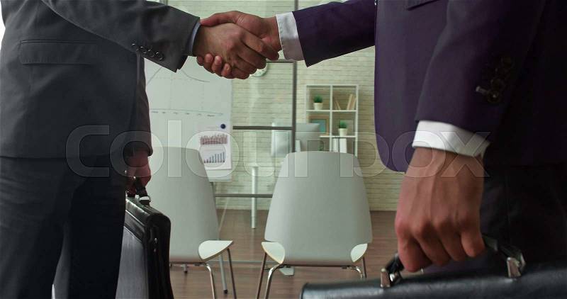 Partners meeting in office and shaking hands, stock photo