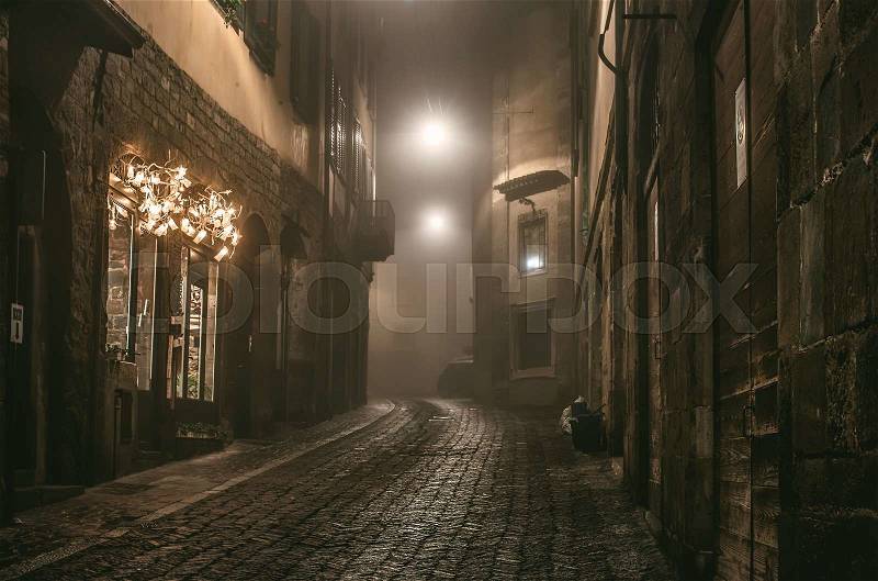 Old European narrow empty street of medieval town on a foggy evening. Taken in Bergamo, Citta Alta, Lombardia, stock photo