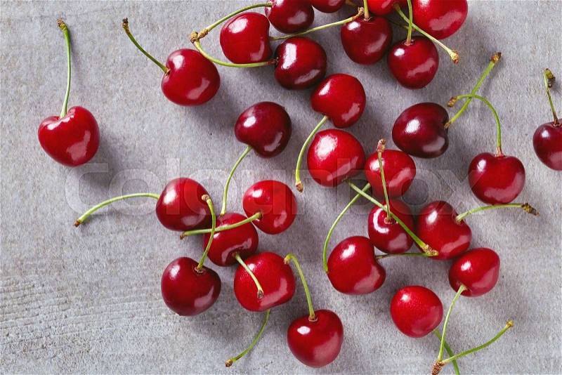 Ripe red cherries on stone table, top view, stock photo