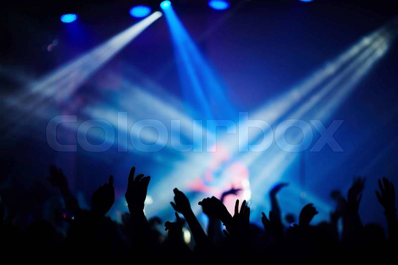 Fans dancing during the concert of popular singer, stock photo