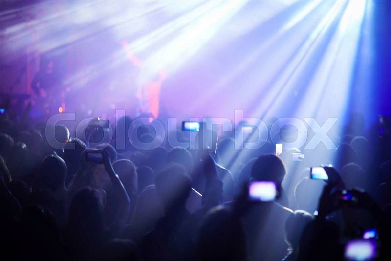 People listening to the singer recording him with smartphones, stock photo