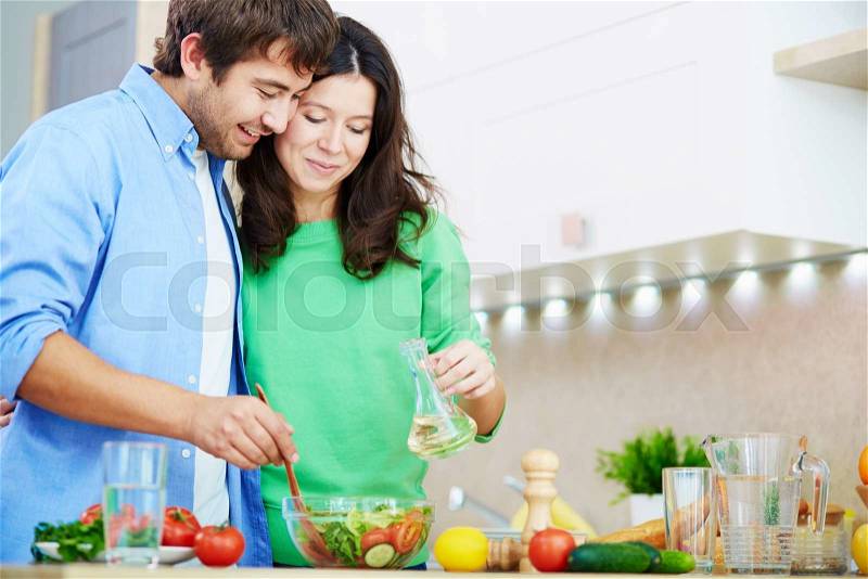 Yong couple cooking healthy dinner together, stock photo