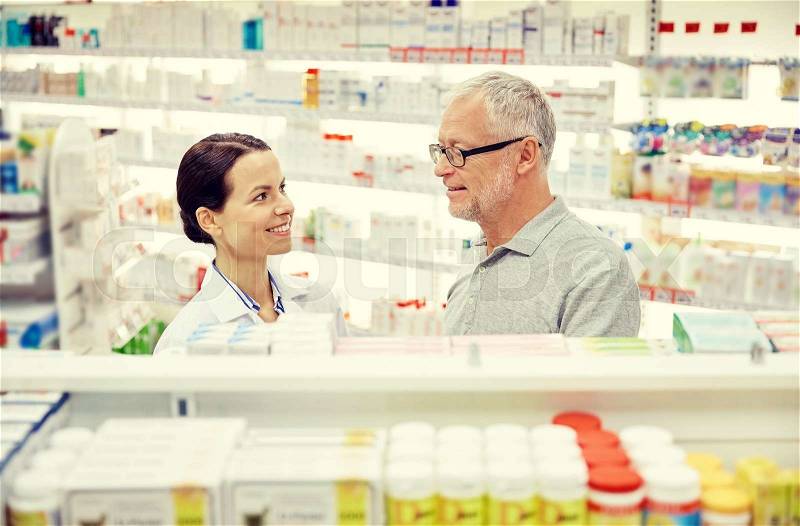 Medicine, pharmaceutics, health care and people concept - happy pharmacist talking to senior man customer at drugstore, stock photo