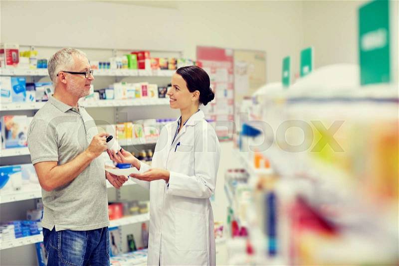 Medicine, pharmaceutics, health care and people concept - happy pharmacist giving drug to senior man customer and taking prescription at drugstore, stock photo