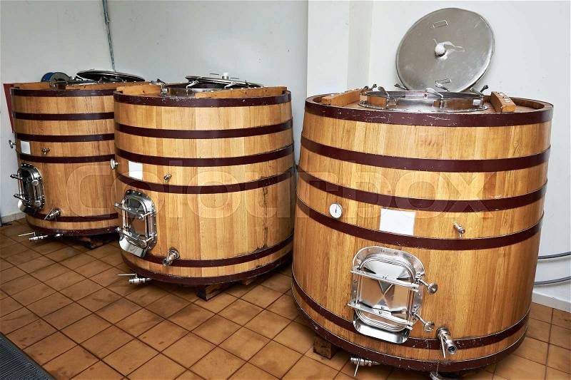 Wooden tank barrels for aging wine at the winery, stock photo
