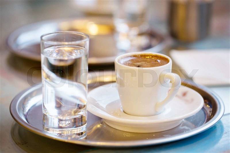 Cup of coffee and glass of water on cafe table, stock photo