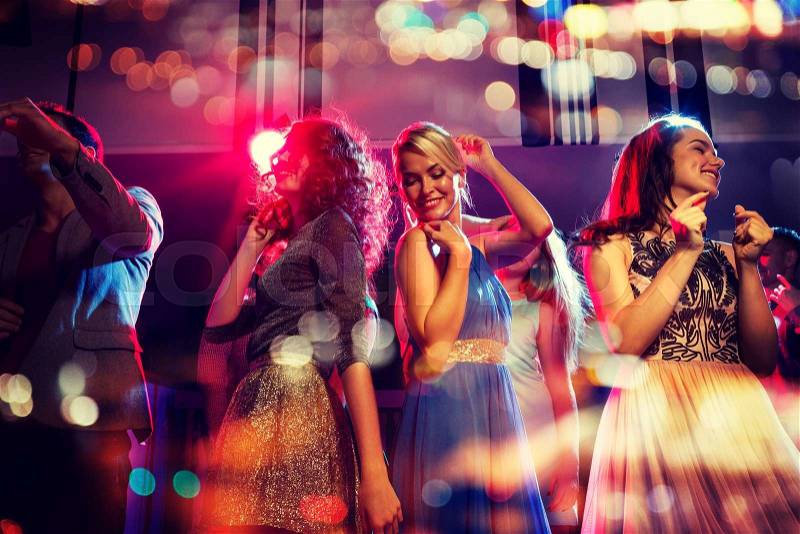 Party, holidays, celebration, nightlife and people concept - happy friends dancing in club with holidays lights, stock photo