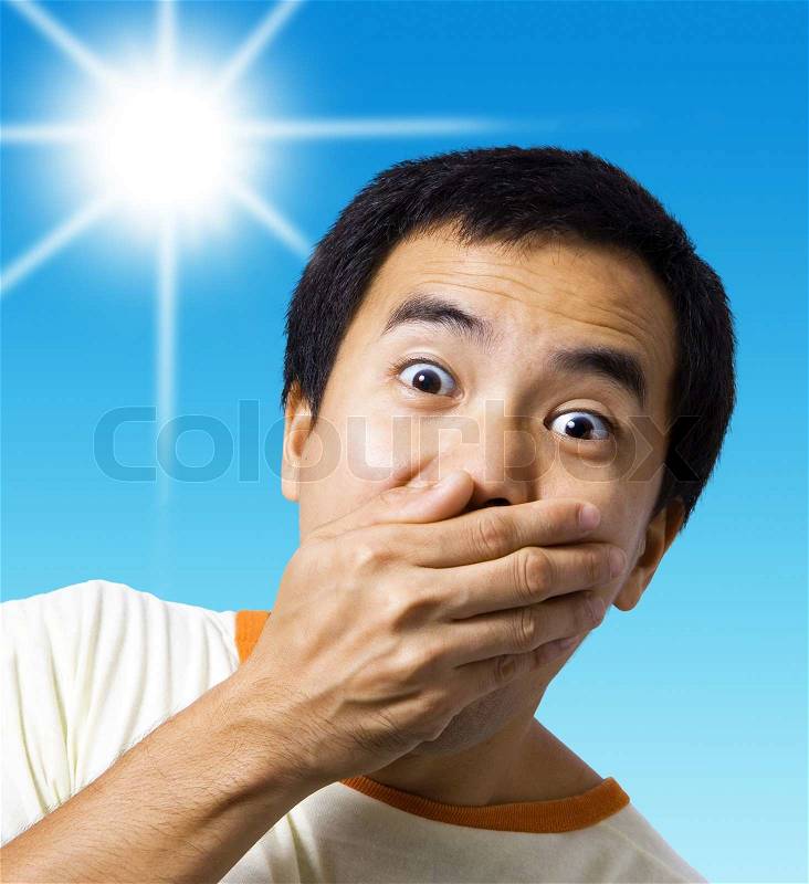 A stunned and shocked man with his hand over his mouth, stock photo