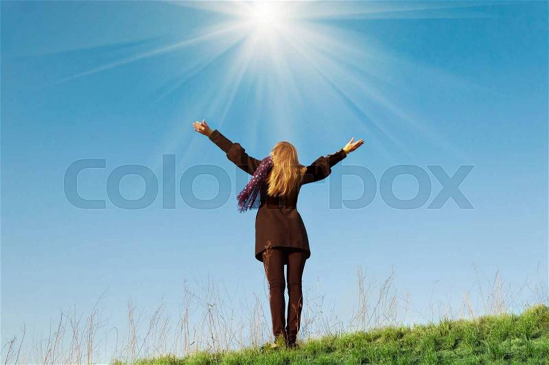 Young girl praying pulls his hand to the light turning to God, stock photo
