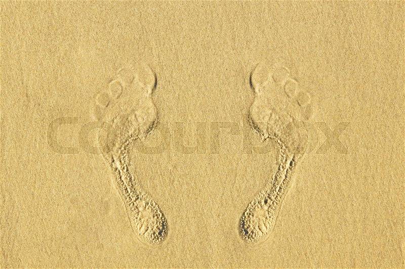 Human footprints on the sand at the beach. The concept of a beach holiday, stock photo