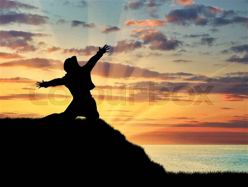 Concept of emotions and feelings. Silhouette of happy man on the top of a hill on a background of sea sunset, stock photo