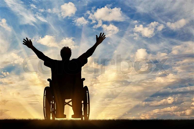 Concept of disability and disease. Silhouette happy disabled person in a wheelchair at sunset , stock photo