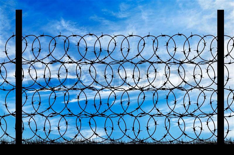 Concept of security. Silhouette of a metal fence with barbed wire on the background of the beautiful sky, stock photo