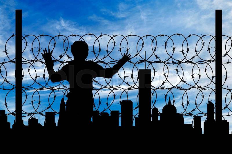 Safety concept. Silhouette of a refugee near the fence of barbed wire on the background of the city away, stock photo