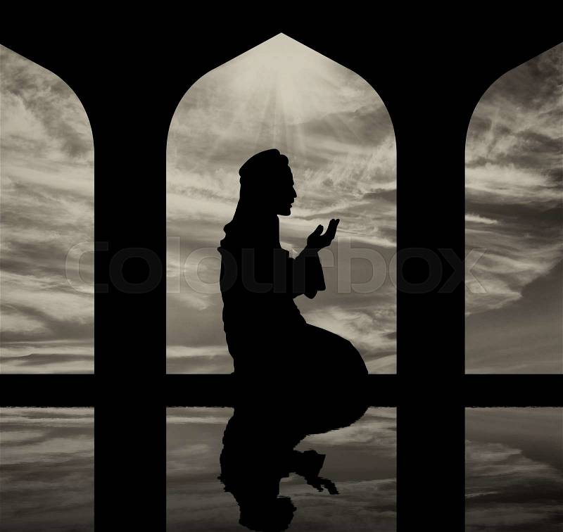 The concept of the Islamic religion. Silhouette of man praying at the Town Hall and reflection, stock photo