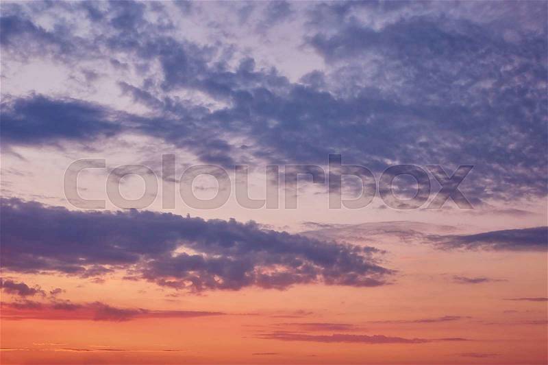 Beautiful cloudy evening sky with sun rays with purple tinge, stock photo