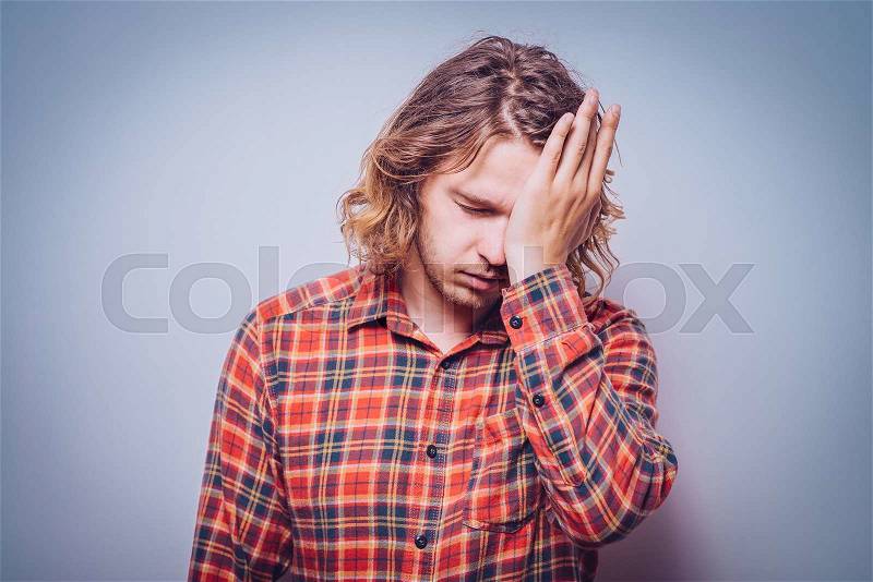 man covers his face by hand, stock photo