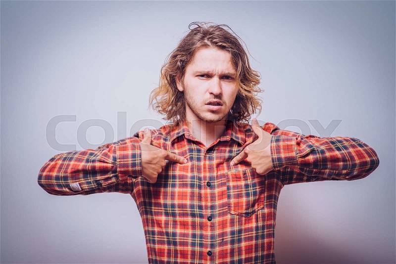 Male hand forefinger pointing to himself on the chest. Gesture. who am i. On a gray background, stock photo