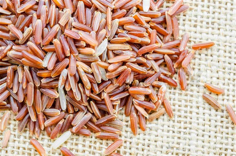 Red rice on sack background, stock photo