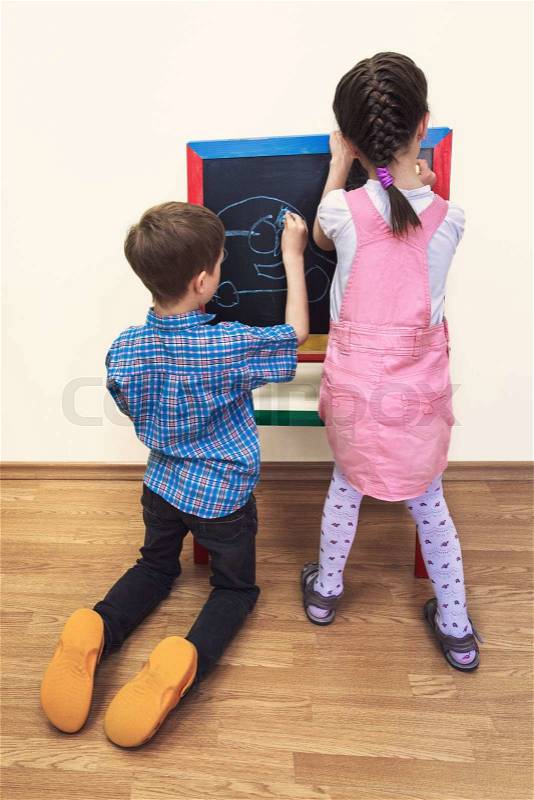 Little preschool children draw on a board, stock photo