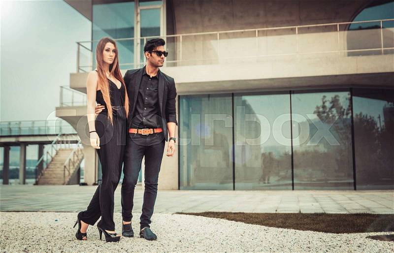 Young trendy man and woman models walks of the modern street. Fashion Style, stock photo