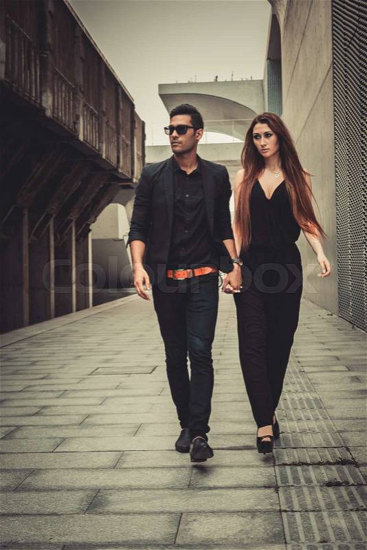 Young trendy man and woman models walks of the modern street. Fashion Style, stock photo