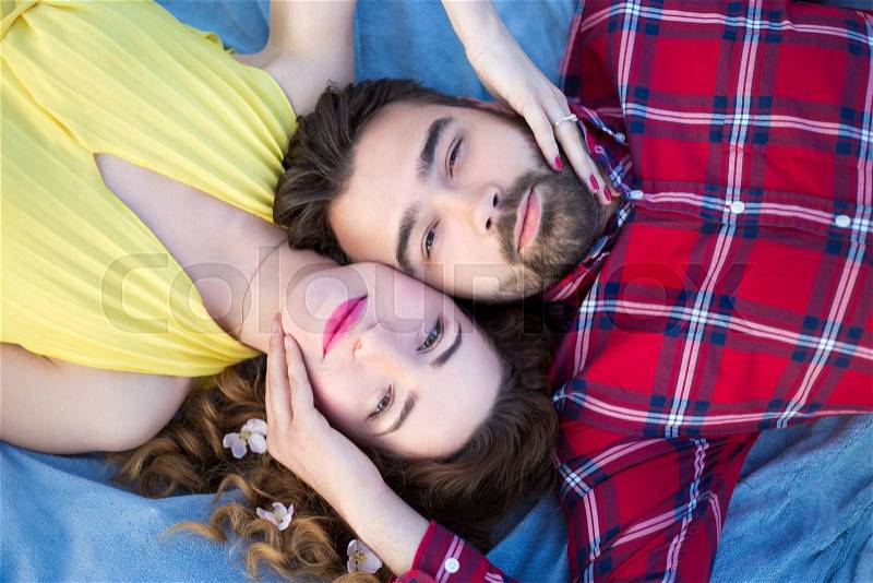 Top view portrait of young beautiful couple lying on blanket, stock photo