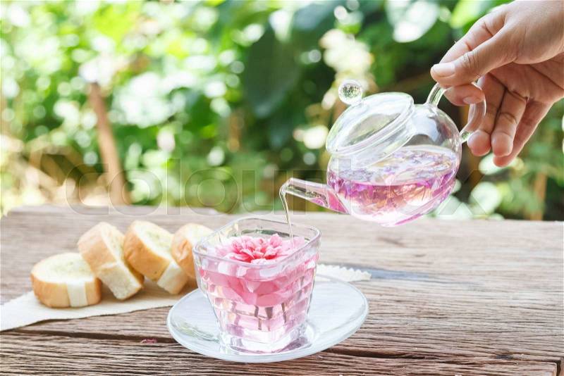 Afternoon tea break, rose tea with tea pot in the garden, stock photo