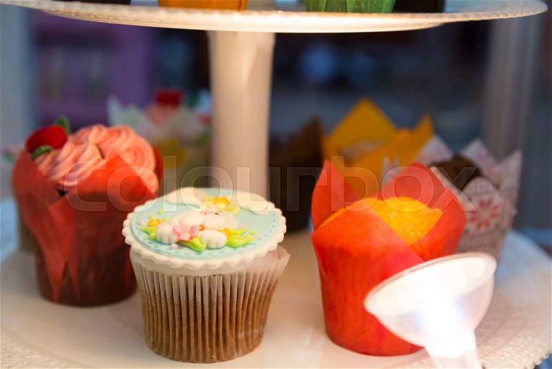 Sweet cakes in colored packing on the shelf, stock photo