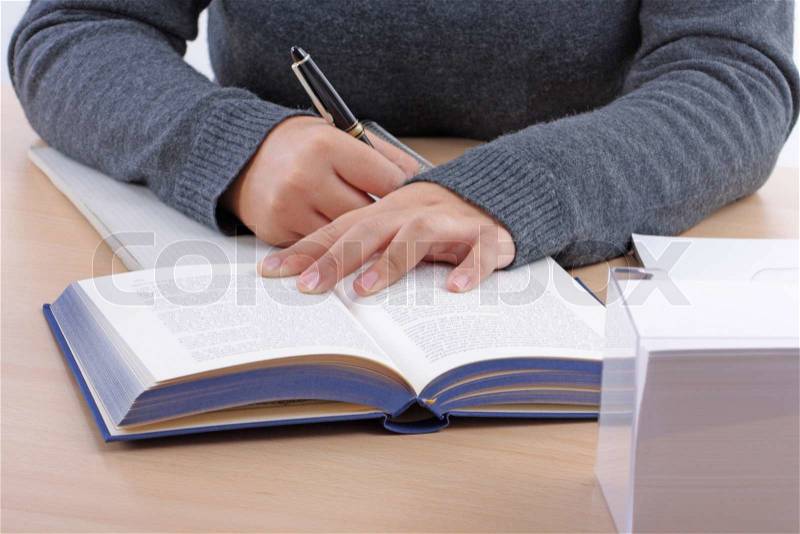 A young woman\'s hand writing on a writing pad, stock photo