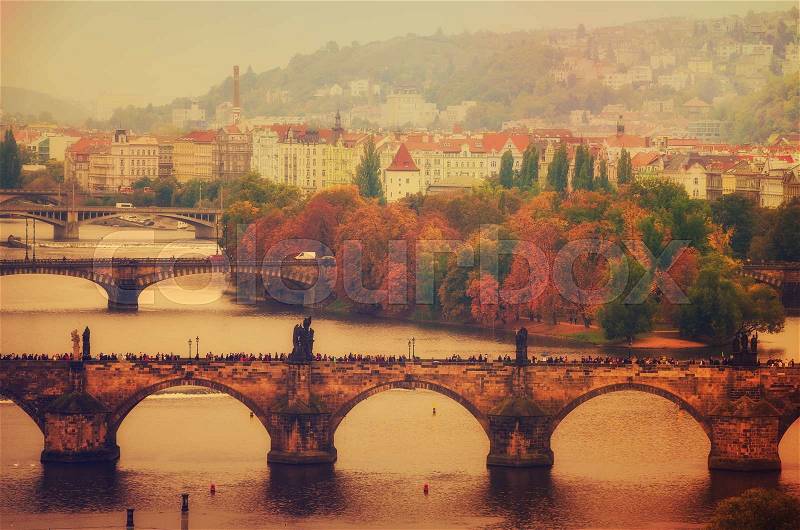 Center of Prague city at autumn with red roofs and Charles Bridge over river Vltava, european travel landscape background in vintage style, stock photo