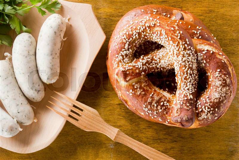 German pretzels and sausages on wooden background, stock photo
