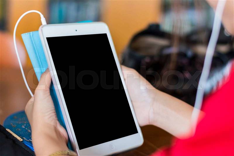 Close up white tablet with a white screen in the woman hands on table , soft - focus, stock photo