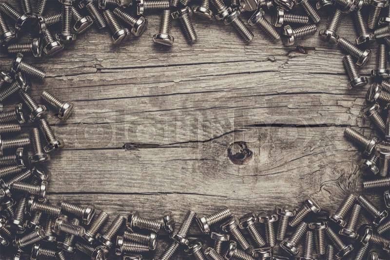 New bolts on the wooden table background, stock photo