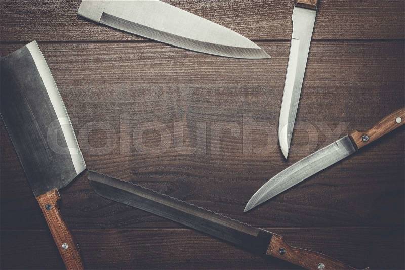 Kitchen knifes on the brown wooden table background, stock photo