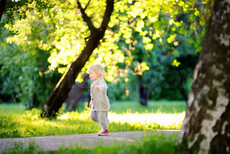 Toddler boy running in the park at the spring or summer day, stock photo