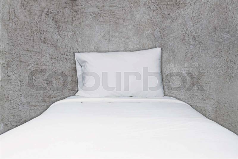 Close up white bedding and pillow on abstract gray concrete texture background, stock photo