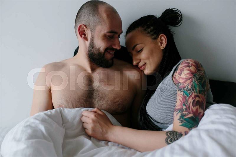 Handsome man and beautiful woman on the bed, stock photo
