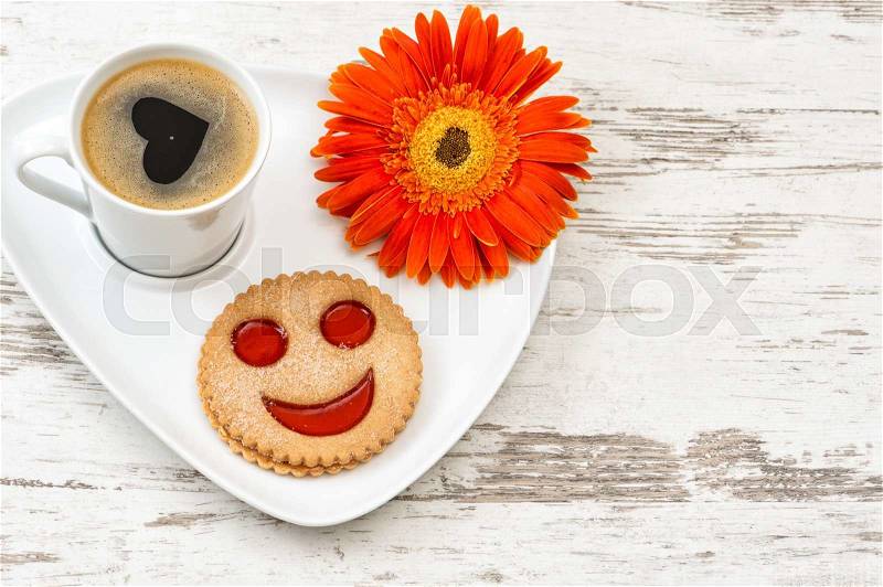 Cup of black coffee with smiled cookie on wooden background. Heart, love, flower, stock photo
