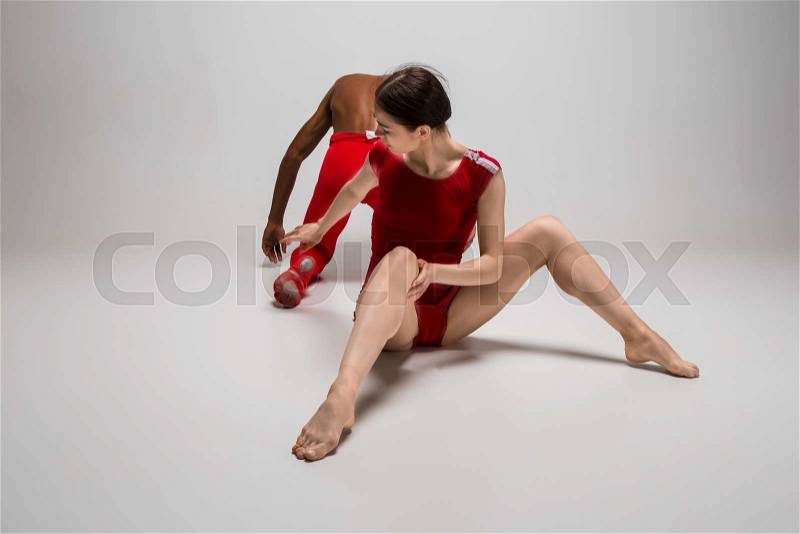 Couple of ballet dancers dancing over gray background, stock photo