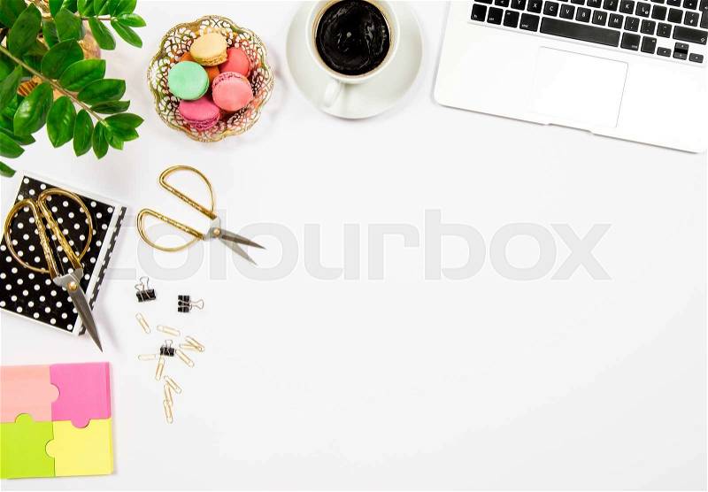 Feminine office desk workplace. Coffee, cookies, laptop computer and gren plant on white table background. Top view. Flat lay, stock photo