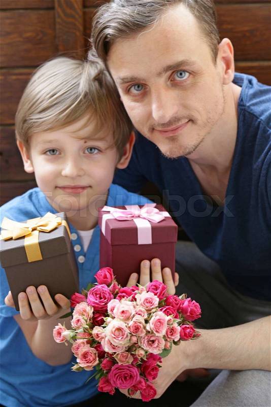 Husband and son presented to mom flowers and gifts, stock photo