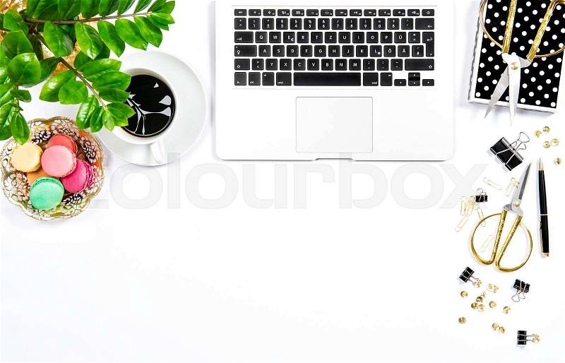 Coffee, macaroon cookies, office supplies, laptop computer and green plant on white table background. Business still life, stock photo