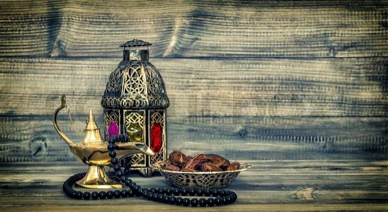 Antique arabic lantern and islamic rosary beads. Oriental holidays decoration with dates fruits. Vintage style toned picture, stock photo