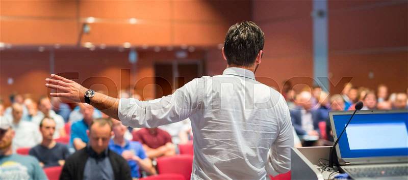 Speaker giving a talk on corporate Business Conference. Audience at the conference hall. Business and Entrepreneurship event, stock photo