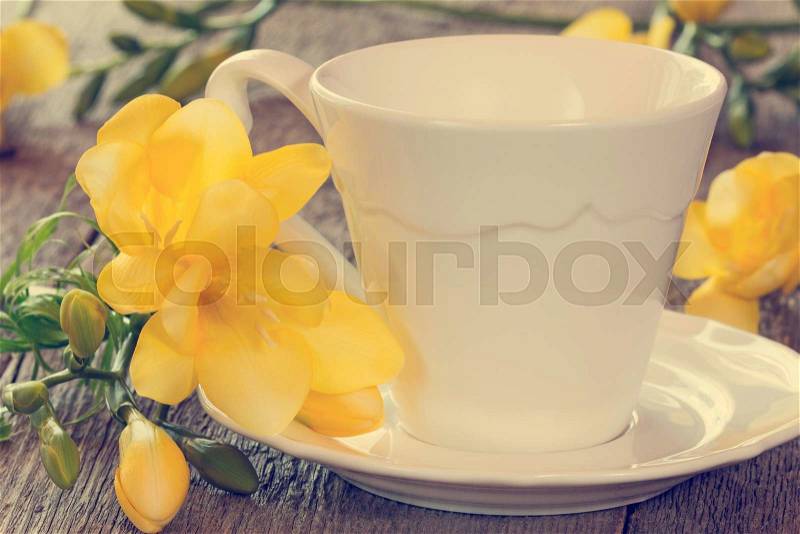 Soft pastel still life with freesia flowers and tea cup, stock photo