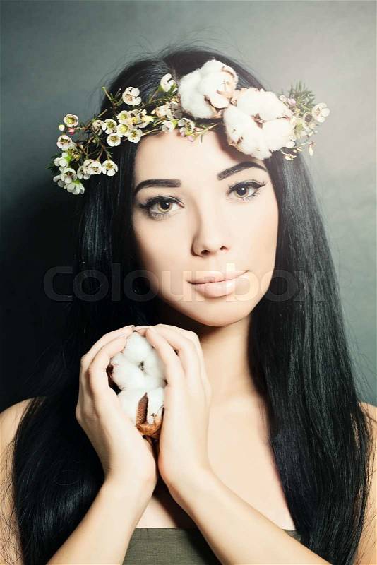 Beautiful brunette woman with cotton flowers in her hair and hand. Fashion photo, stock photo