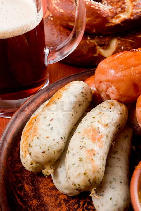 Traditional sausages, pretzels and beer on a wooden background, stock photo