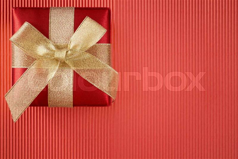Gift box on red corrugated paper background, stock photo