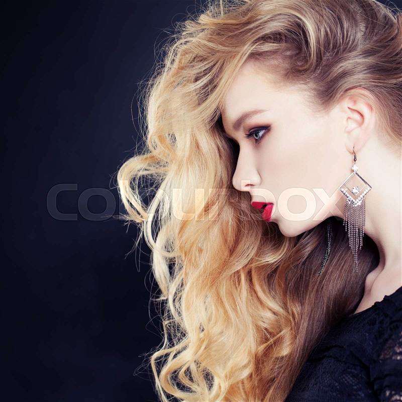 Female Profile. Beautiful Woman with Long Wavy Blonde Hair on Dark Background, stock photo